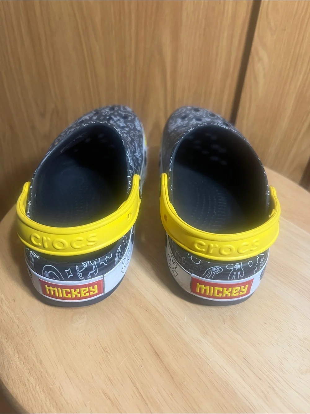 CROCS Kids Black Clogs with Yellow Heel Straps and White Doodle Prints